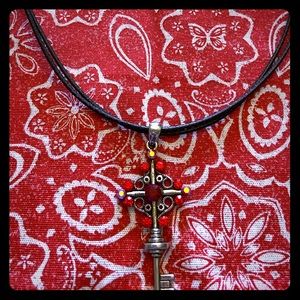 Jeweled cross/key pendant on a black rope necklace
